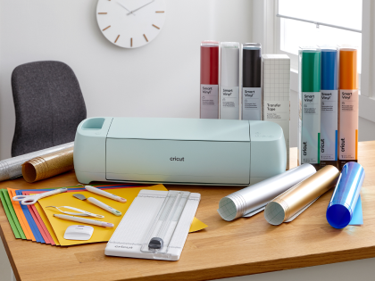 Cricut Explore 3 surrounded by an array of materials and tools